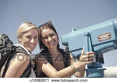 Stock Image - Young woman with telescope. Fotosearch