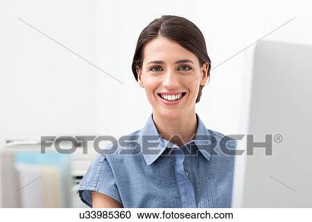 Young woman working on computer View Large Photo Image Stock Image - Young woman working on computer. Fotosearch