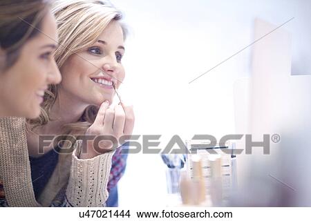 Young women applying make up View Large Photo Image Picture - Young women applying make up. Fotosearch