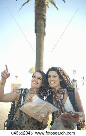 Young women looking at map and pointing View Large Photo Image Stock Photography - Young women looking at map and pointing. Fotosearch
