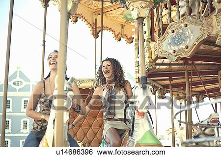 Stock Photograph - Young women riding carousel. Fotosearch