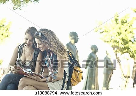 Young women sitting looking at map View Large Photo Image Picture - Young women sitting looking at map. Fotosearch