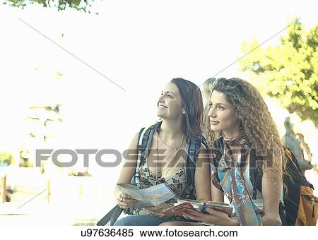 Young women sitting looking at map View Large Photo Image Stock Photography - Young women sitting looking at map. Fotosearch