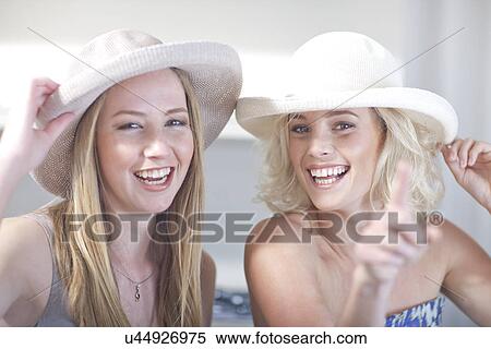 Young women trying on hats View Large Photo Image Stock Photography - Young women trying on hats. Fotosearch