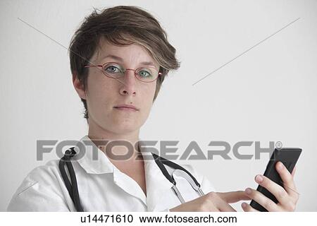 Stock Image - Doctor using a mobile phone. Fotosearch