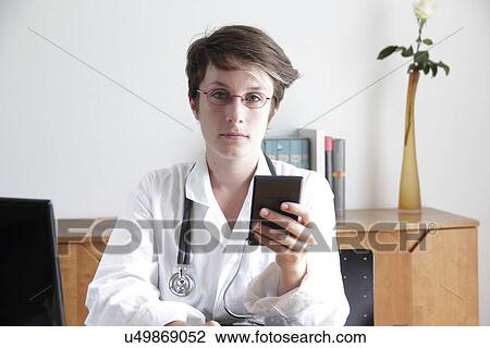 Doctor using a mobile phone View Large Photo Image Stock Image - Doctor using a mobile phone. Fotosearch