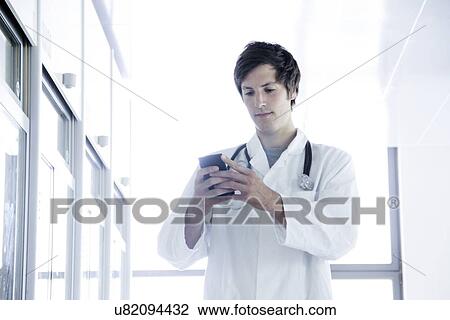 Doctor using a mobile phone View Large Photo Image Stock Image - Doctor using a mobile phone. Fotosearch