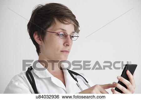 Stock Photograph - Doctor using a mobile phone. Fotosearch