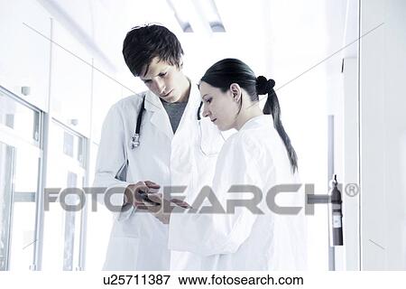Stock Photo - Doctors discussing notes. Fotosearch
