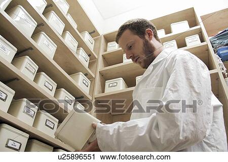 Stock Image - Pharmacist selecting drugs. Fotosearch