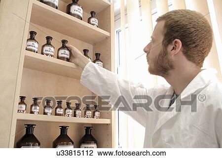 Stock Image - Pharmacist selecting drugs. Fotosearch