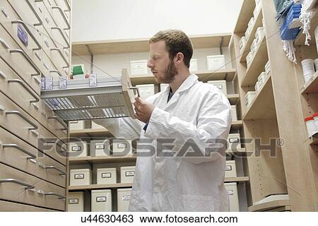 Stock Image - Pharmacist selecting drugs. Fotosearch