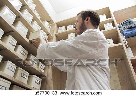 Stock Image - Pharmacist selecting drugs. Fotosearch