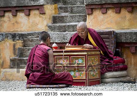 Stock Photography - Buddhist monk reciting teachings of Buddha to his pupil in Sera Monastery, Lhasa, Tibet, China. Fotosearch