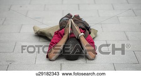 Stock Image - Buddhist pilgrim prostrating on a street, Lhasa, Tibet, China. Fotosearch