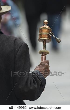 Buddhist pilgrim with prayer wheel on a street, Lhasa, Tibet, China View Large Photo Image Stock Image - Buddhist pilgrim with prayer wheel on a street, Lhasa, Tibet, China. Fotosearch