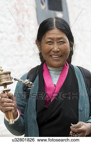 Buddhist woman with prayer wheel in Drepung Monastery, Lhasa, Tibet, China View Large Photo Image Stock Photograph - Buddhist woman with prayer wheel in Drepung Monastery, Lhasa, Tibet, China. Fotosearch