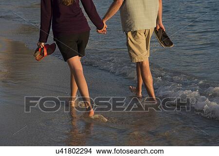 Picture - Couple walking holding hands on the beach, Waikiki, Honolulu, Oahu, Hawaii, USA. Fotosearch