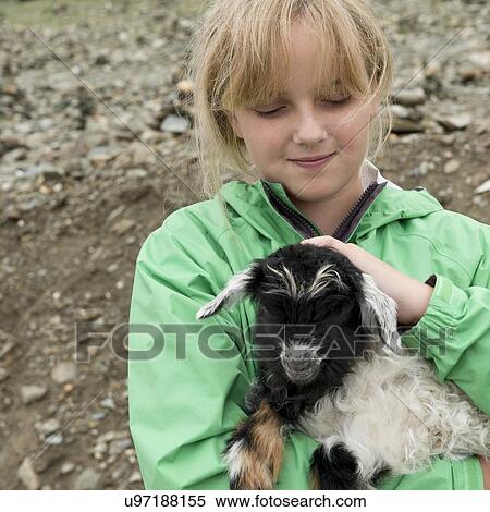 Stock Photography - Girl holding a lamb, Nagarze, Shannan, Tibet, China. Fotosearch