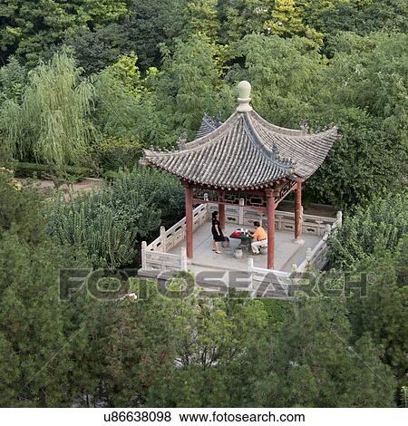 Husband and wife spending time under a roof structure at park, Xi'an, Shaanxi, China. View Large Photo Image Stock Photo - Husband and wife spending time under a roof structure at park, Xi'an, Shaanxi, China.. Fotosearch