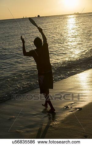 Man playing on the beach at sunset, Waikiki, Honolulu, Oahu, Hawaii, USA View Large Photo Image Stock Photograph - Man playing on the beach at sunset, Waikiki, Honolulu, Oahu, Hawaii, USA. Fotosearch