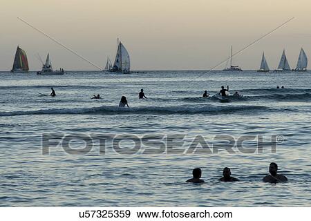People enjoying on the beach with sailboats in the background, Waikiki, Honolulu, Oahu, Hawaii, USA View Large Photo Image Stock Photo - People enjoying on the beach with sailboats in the background, Waikiki, Honolulu, Oahu, Hawaii, USA. Fotosearch