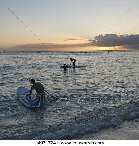 People paddleboarding in the ocean at sunset, Waikiki, Honolulu, Oahu, Hawaii, USA View Large Photo Image Stock Image - People paddleboarding in the ocean at sunset, Waikiki, Honolulu, Oahu, Hawaii, USA. Fotosearch