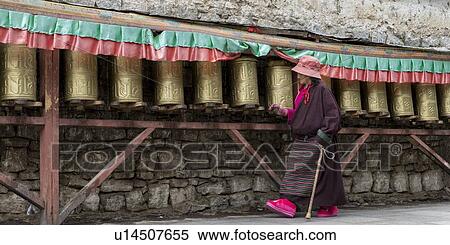 Stock Photography - Pilgrim spinning prayer wheels at Potala Palace, Lhasa, Tibet, China. Fotosearch