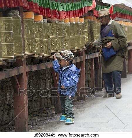 Stock Photography - Pilgrims spinning prayer wheels at Potala Palace, Lhasa, Tibet, China. Fotosearch