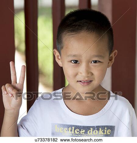 Stock Image - Portrait of a happy little boy gesturing, Xi'an, China.. Fotosearch