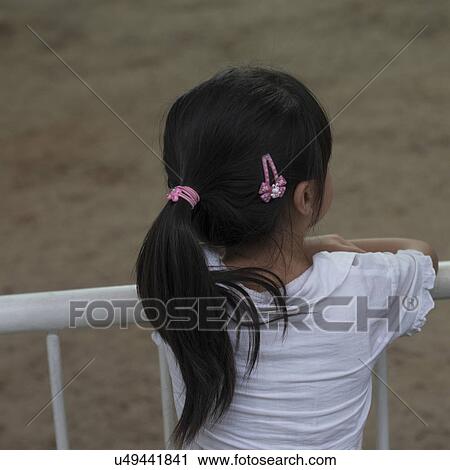 Stock Image - Rear view of a girl at Terracotta Warriors Army Museum, Xi'an, Shaanxi, China.. Fotosearch