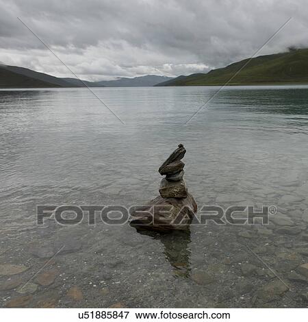 Stock Photo - Stack of stones in the Yamdrok Lake, Nagarze, Shannan, Tibet, China. Fotosearch