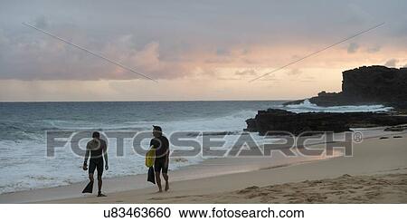Stock Image - Surfers on the beach, Sandy Beach, Hawaii Kai, Honolulu, Oahu, Hawaii, USA. Fotosearch