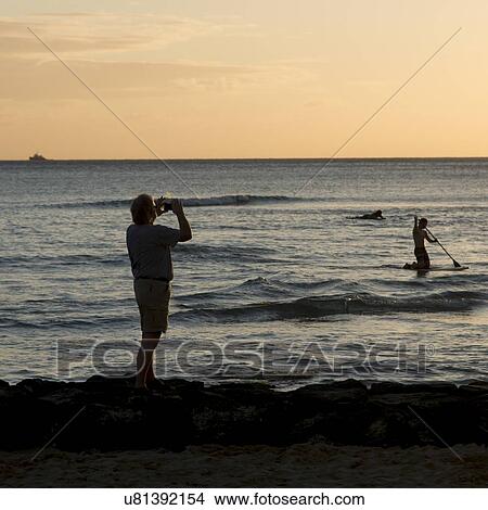 Picture - Tourists on the beach at sunset, Waikiki, Honolulu, Oahu, Hawaii, USA. Fotosearch