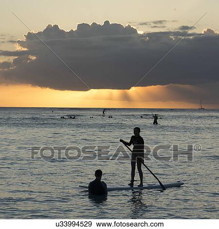 Stock Photo - Tourists on the beach at sunset, Waikiki, Honolulu, Oahu, Hawaii, USA. Fotosearch