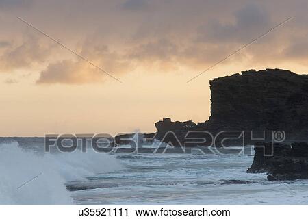 Stock Image - Waves on the beach at sunset, Sandy Beach, Hawaii Kai, Honolulu, Oahu, Hawaii, USA. Fotosearch