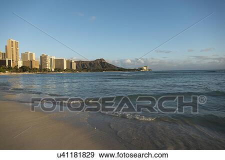 Stock Photo - Waves on the beach with buildings in the background, Waikiki, Honolulu, Oahu, Hawaii, USA. Fotosearch