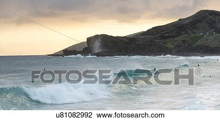 Waves on the beach with surfers at dusk, Sandy Beach, Honolulu, Oahu, Hawaii, USA View Large Photo Image Stock Image - Waves on the beach with surfers at dusk, Sandy Beach, Honolulu, Oahu, Hawaii, USA. Fotosearch