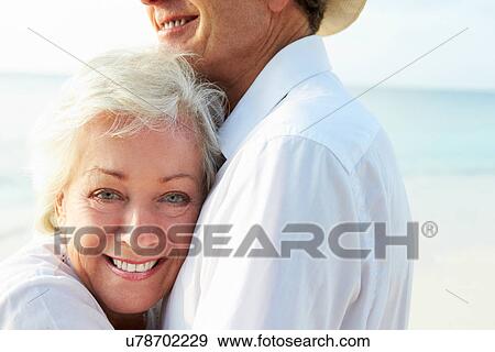 Stock Photo - Affectionate Senior Couple On Tropical Beach Holiday. Fotosearch