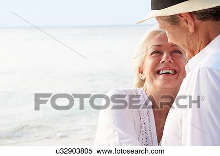 Stock Photography - Affectionate Senior Couple On Tropical Beach Holiday. Fotosearch