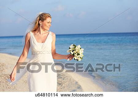 Picture - Beautiful Bride Getting Married In Beach Ceremony. Fotosearch