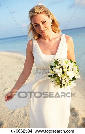 Picture - Beautiful Bride Getting Married In Beach Ceremony. Fotosearch