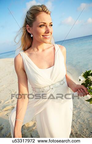Stock Image - Beautiful Bride Getting Married In Beach Ceremony. Fotosearch