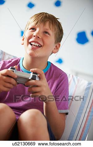 Stock Photo - Boy Holding Controller Playing Video Game. Fotosearch