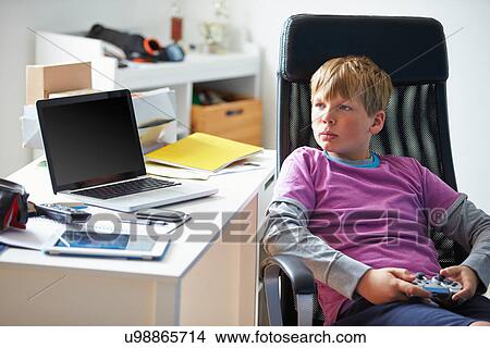 Boy Playing Video Game In Bedroom View Large Photo Image Picture - Boy Playing Video Game In Bedroom. Fotosearch