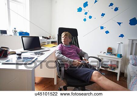 Stock Image - Boy Playing Video Game In Bedroom. Fotosearch