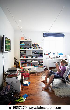 Boy Playing Video Game In Bedroom View Large Photo Image Stock Photo - Boy Playing Video Game In Bedroom. Fotosearch
