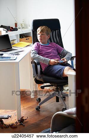 Boy Playing Video Game In Bedroom View Large Photo Image Stock Photo - Boy Playing Video Game In Bedroom. Fotosearch