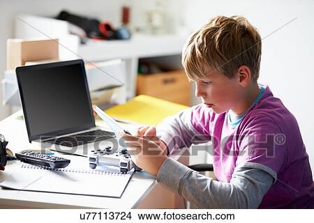 Boy Using Digital Tablet In Bedroom View Large Photo Image Picture - Boy Using Digital Tablet In Bedroom. Fotosearch