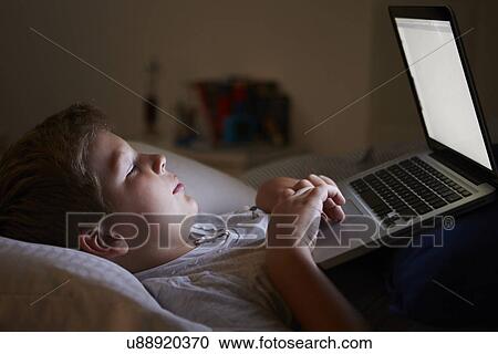 Boy Using Laptop In Bed At Night View Large Photo Image Stock Image - Boy Using Laptop In Bed At Night. Fotosearch